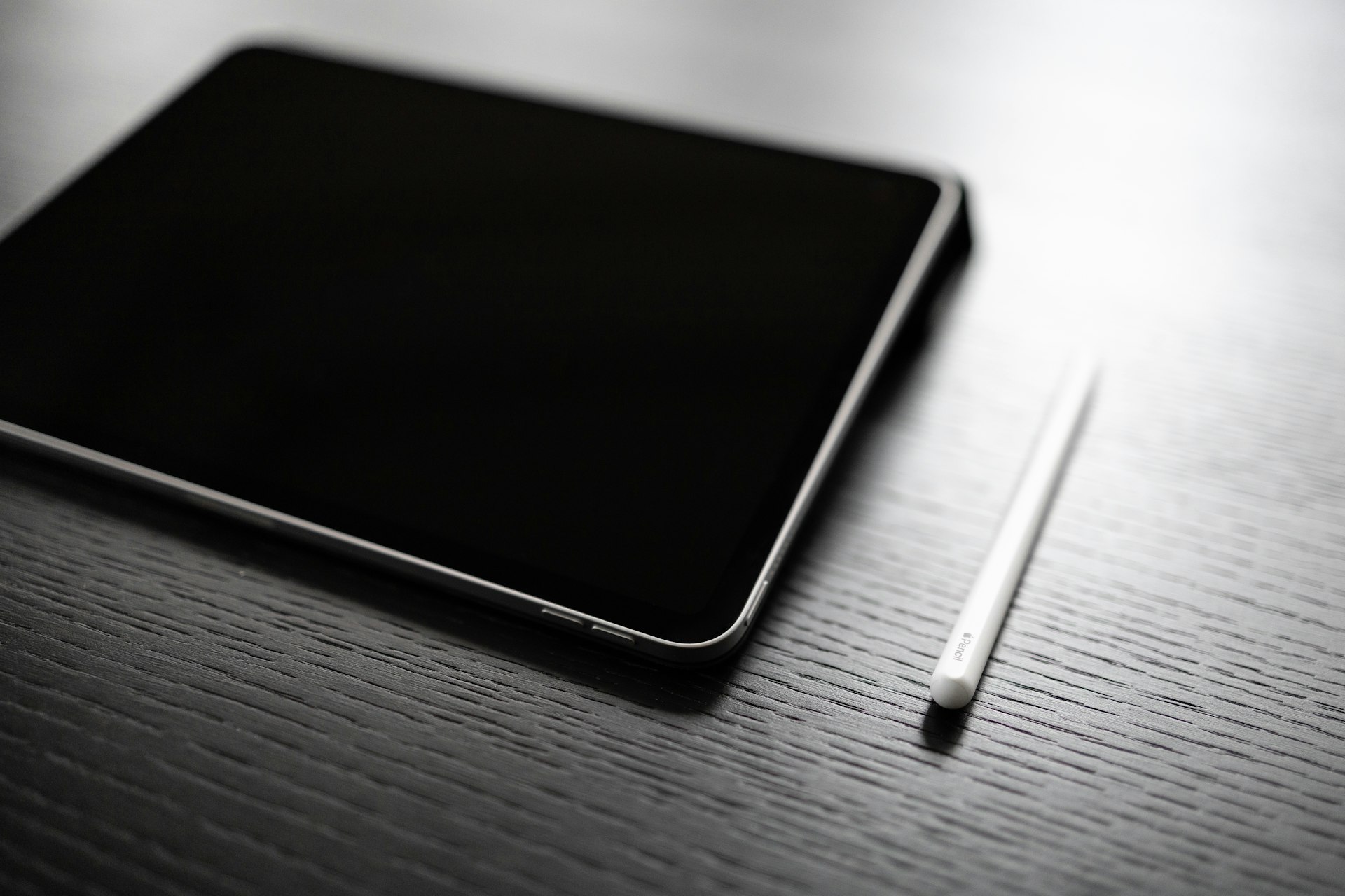 black tablet computer on brown wooden table